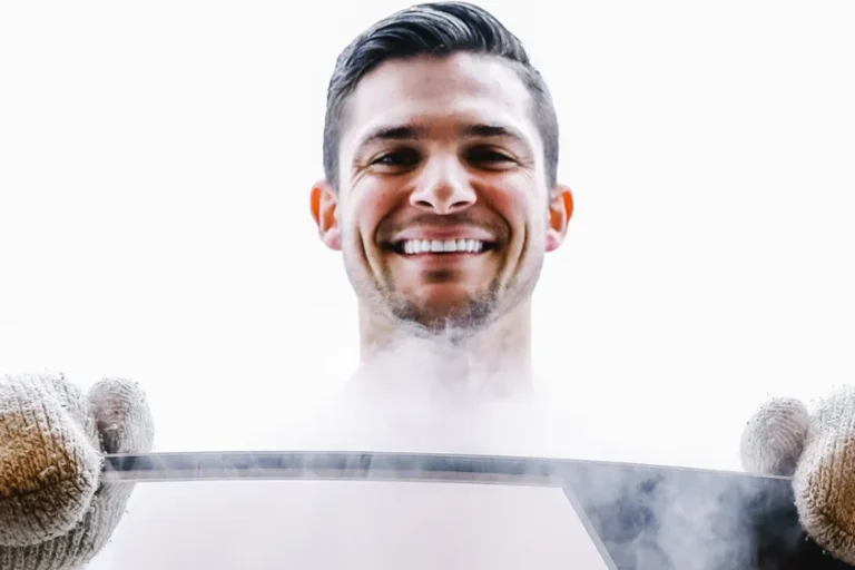 A man with wool gloves smiling during cryotherapy.