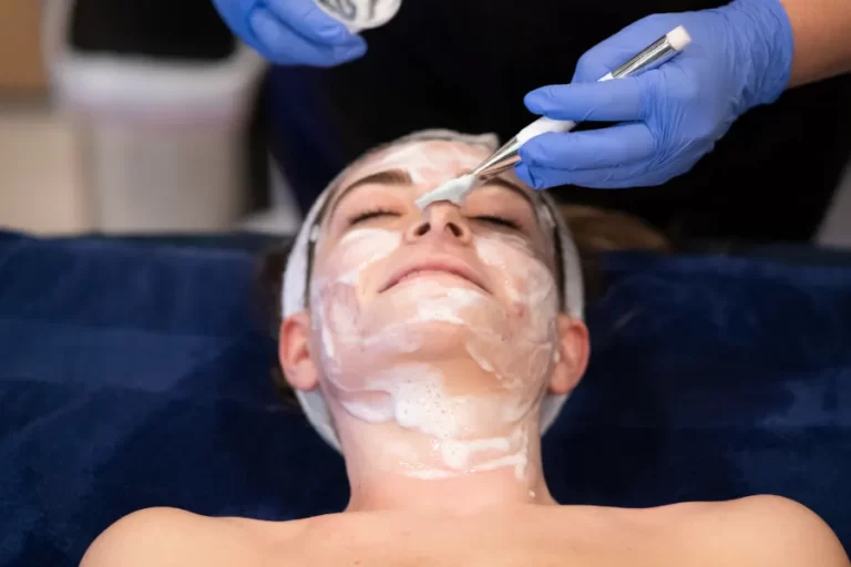 A woman with face cream being prepared for a procedure.